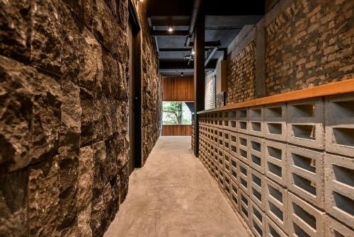 a hallway of a building with a stone wall at Domo Japanese Style Bedroom in Melaka