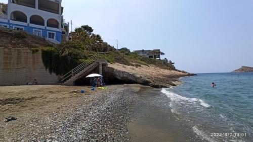 a beach with a staircase leading to the ocean at Aegean Villita on beach apartment in Kalymnos