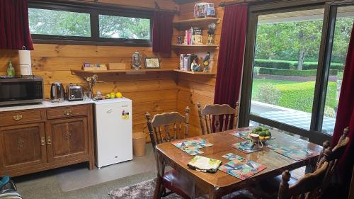 een keuken met een tafel en een witte koelkast bij Fantail Garden in Walton