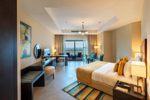 a hotel room with a bed and a desk at Al Bahar Hotel & Resort in Fujairah