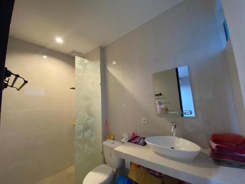W łazience znajduje się umywalka, toaleta i lustro. w obiekcie RSY GUEST HOUSE Argopuro w mieście Berpodak