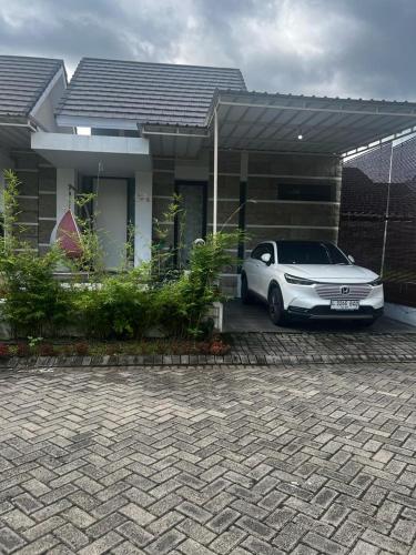 un coche blanco estacionado frente a una casa en RSY GUEST HOUSE Argopuro, en Berpodak