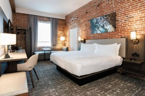 a hotel room with a large bed and a brick wall at Columbus Marriott in Columbus