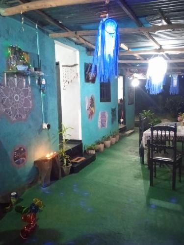 a room with a green floor and a blue wall at Cozy House Hostel in Ella