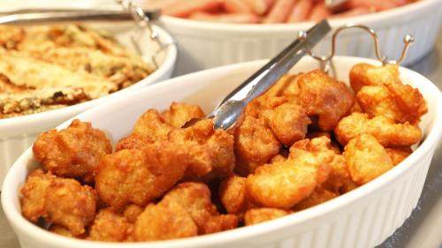a bowl of fried food with a spoon in it at Dormy Inn Tsu in Tsu