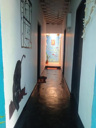 an empty hallway with a painting of a dinosaur on the wall at Cozy House Hostel in Ella