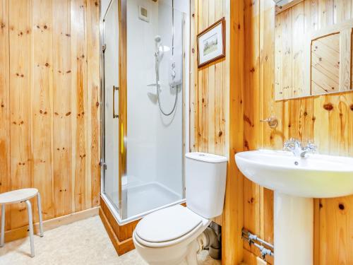 a bathroom with a toilet and a sink and a shower at Stuffers Cottage in Inverey