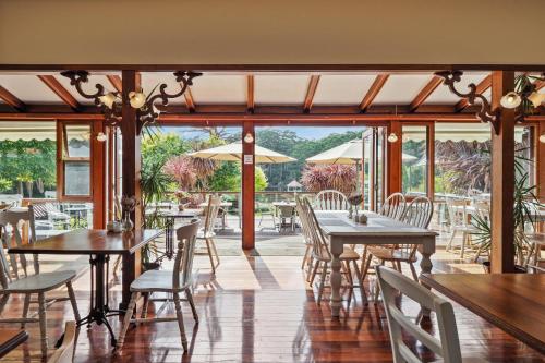 a dining room with tables and chairs and windows at Forest Lodge Resort in Pemberton