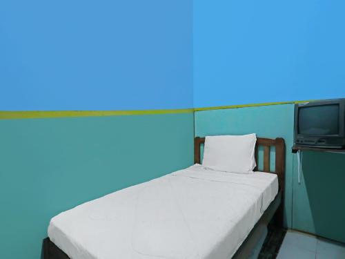 a small bedroom with a bed and a tv at SPOT ON 92538 Joyoakis Homestay Syariah in Nagoya