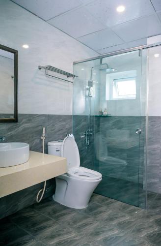 a bathroom with a toilet and a sink and a shower at Orchid Riverside Villa in Hue