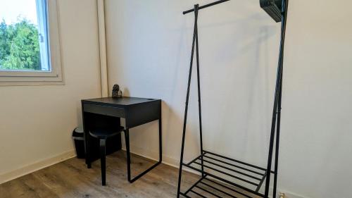 a black desk and a chair in a room at Chambre Chez l'habitant - Chez Fab in Alençon