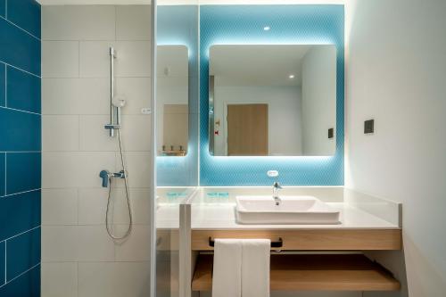 een badkamer met een wastafel en een spiegel bij Holiday Inn Express Jinan Airport Zone, an IHG Hotel in Jinan