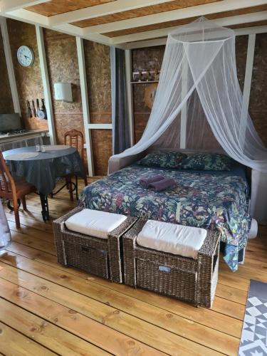 1 dormitorio con cama con dosel y mesa en Eden des laves en Sainte-Rose