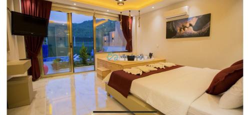 ein Schlafzimmer mit einem Bett, einer Badewanne und einem TV in der Unterkunft Villa flamingo in Kaş