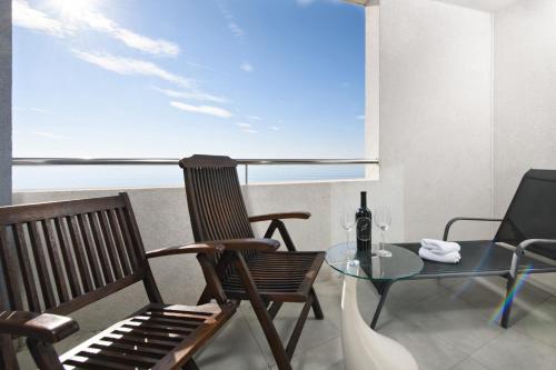 a room with a table and a chair and a glass table and a window at Hotel San Antonio in Podstrana