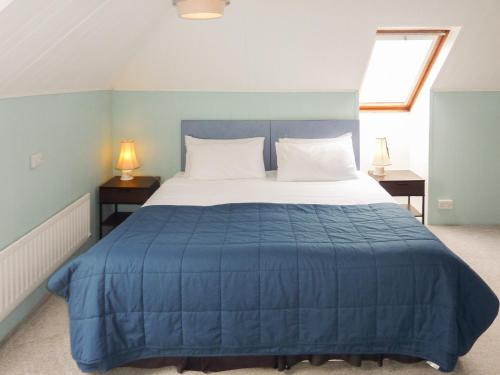 a bedroom with a large bed with a blue blanket at Bosun Retreat in Burton