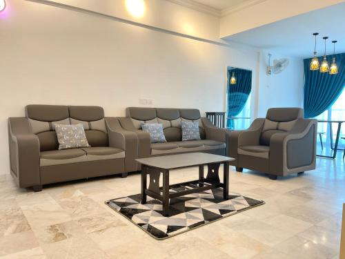 a living room with couches and a coffee table at Century Suria Aparment Langkawi by Zervin in Kuah