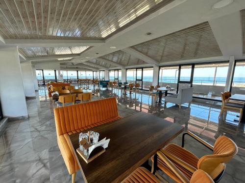 a dining room with a table and chairs and the ocean at Yalıköy Deniz Otel Istanbul in Yalıköy