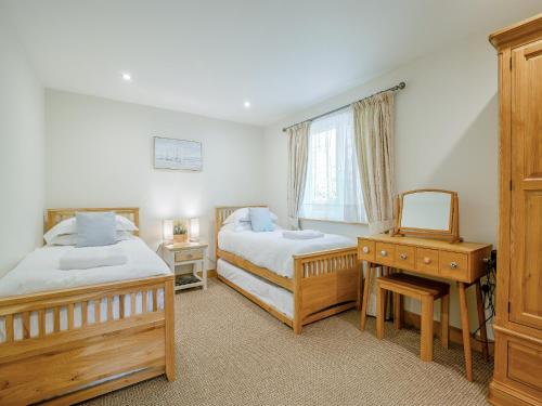 a bedroom with two beds and a desk and a mirror at Twill Lodge - 4 Swandown in Cudworth