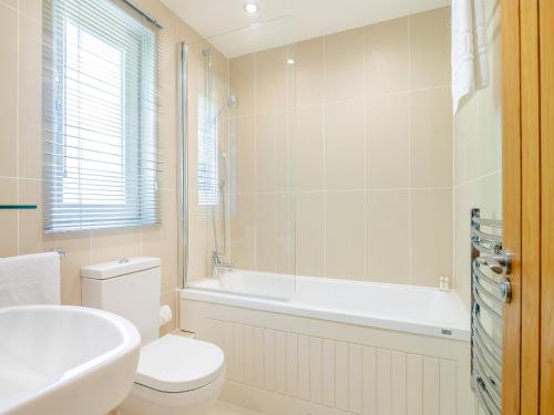 a bathroom with a toilet and a tub and a sink at Twill Lodge - 4 Swandown in Cudworth