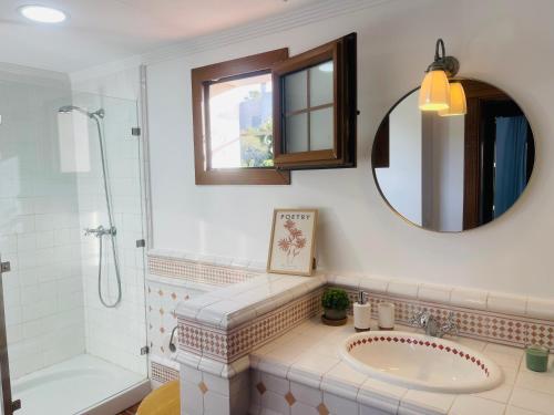 a bathroom with a tub and a sink and a mirror at Sea view Villa La Alcaidesa in La Alcaidesa