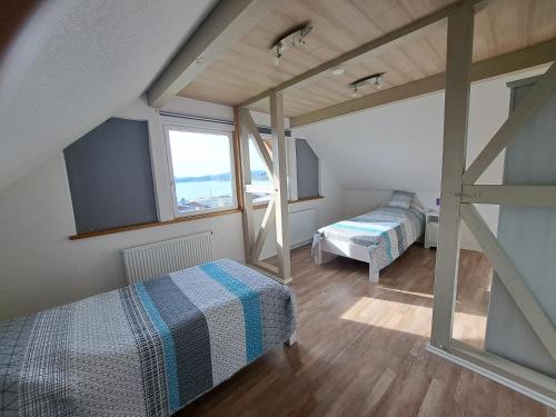 una camera da letto con due letti e una finestra di HM - Ferienhaus 3 Deluxe Krombachtalsperre Westerwald exklusive verbrauchte NK a Driedorf