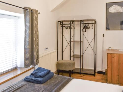 a bedroom with a bed and a chair and a window at Tryfar House in Harlech