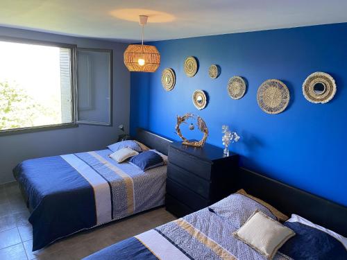 1 dormitorio azul con 2 camas y platos en la pared en Villa de 4 chambres avec piscine privee jacuzzi et jardin clos a Prades, en Prades