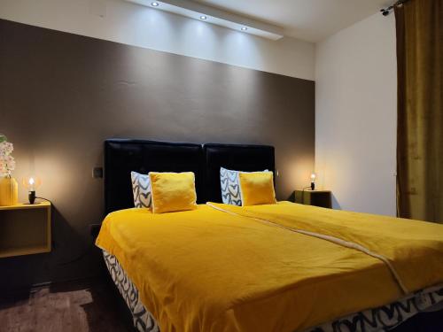 a bedroom with a large yellow bed with two yellow pillows at Golden Sunset 3 in Njivice