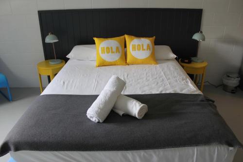 a large white bed with two towels on it at Port Douglas Backpackers in Port Douglas