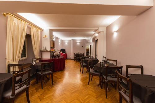 una sala da pranzo con tavoli e sedie in una stanza di Hotel Unicorno a Firenze