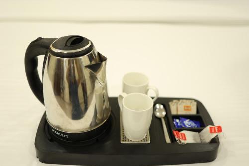 a tea kettle and a cup on a black tray at Perfect Plus just 5 mins walk to Golden Temple in Amritsar
