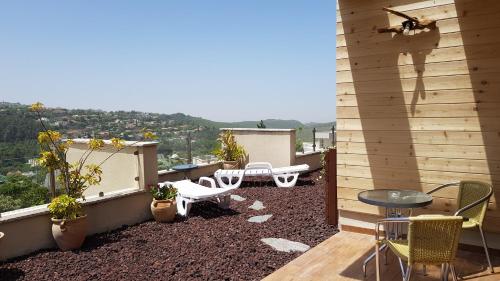 Un patio con sillas y una mesa en el balcón. en ROSEHILLS, en Kefar Weradim