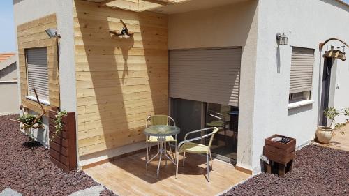 a small patio with a table and chairs on it at ROSEHILLS in Kefar Weradim