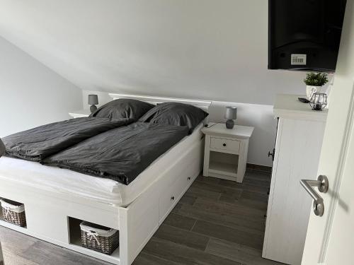 Cama blanca en habitación blanca con pared blanca en Ferienhaus Oskar 100m Entfernung zum See/Strand, en Löbnitz