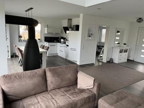 a living room with a couch and a kitchen at Ferienhaus Oskar 100m Entfernung zum See/Strand in Löbnitz