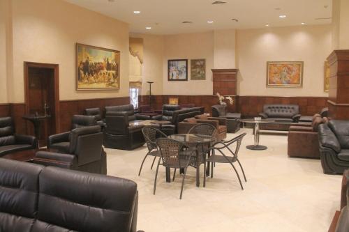 a waiting room with couches and tables and chairs at Le Vendome Hotel in Amman