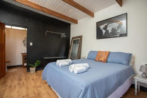 a bedroom with a blue bed with towels on it at Forest Studio in Knysna