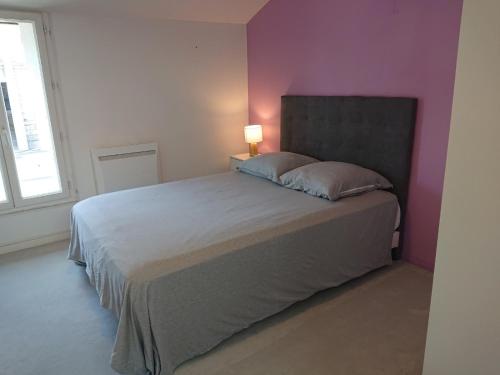 1 dormitorio con 1 cama grande y pared morada en chambre privée à BORDEAUX PELLEGRIN, en Burdeos