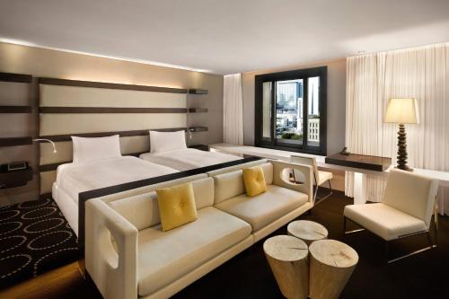 ソウルにあるザ プラザ ソウル オートグラフ コレクションのベッドとソファ付きのホテルルーム