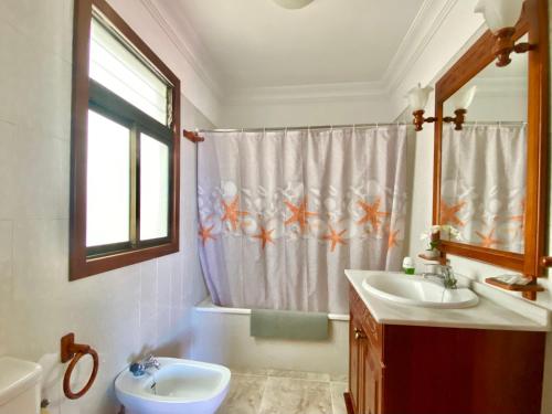 a bathroom with two sinks and a shower curtain at Ático Los Girasoles de La Gallega in Santa Cruz de Tenerife