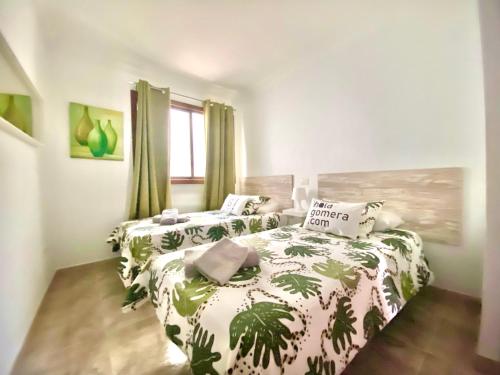 a bedroom with two beds with green plants at Ático Los Girasoles de La Gallega in Santa Cruz de Tenerife