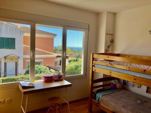 een slaapkamer met een stapelbed en een raam bij Townhouse, private pool garden and sea views in Torremolinos