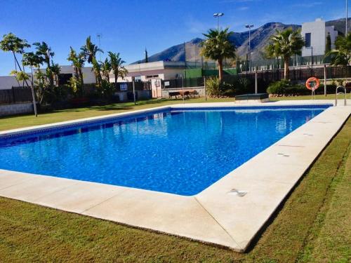 a large swimming pool with blue water at Townhouse, private pool garden and sea views in Torremolinos