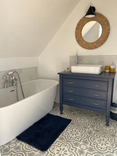 a bathroom with a tub and a sink and a mirror at Le Logis de la Lettre in Tinténiac