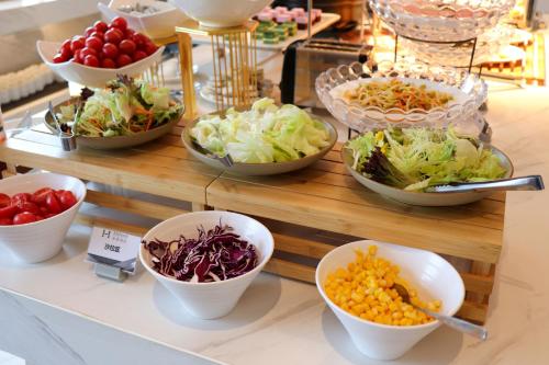 un buffet lleno de tazones de diferentes tipos de comida en Starlit sky Hotel - Shenzhen Luohu Baoneng Center Branch, en Shenzhen
