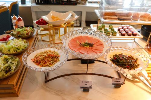 Un buffet con platos de comida en una mesa. en Starlit sky Hotel - Shenzhen Luohu Baoneng Center Branch, en Shenzhen