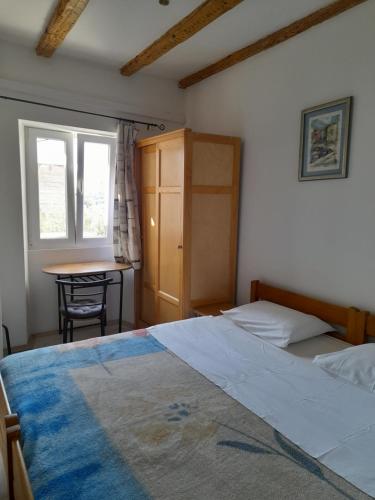 a bedroom with a bed and a table and window at Apartmani Sanja in Šibenik