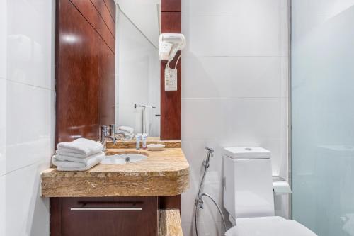 a bathroom with a sink and a toilet at Icon Casa Living - Downtown Burj Views Towers in Dubai