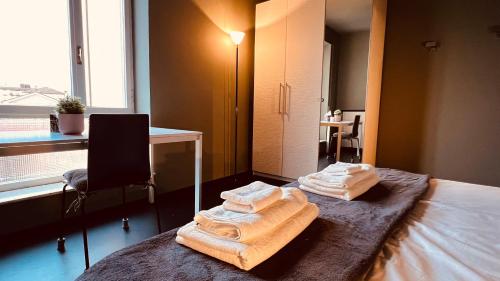 a room with a bed with towels on it at Lounge Apartment Orti in Udine